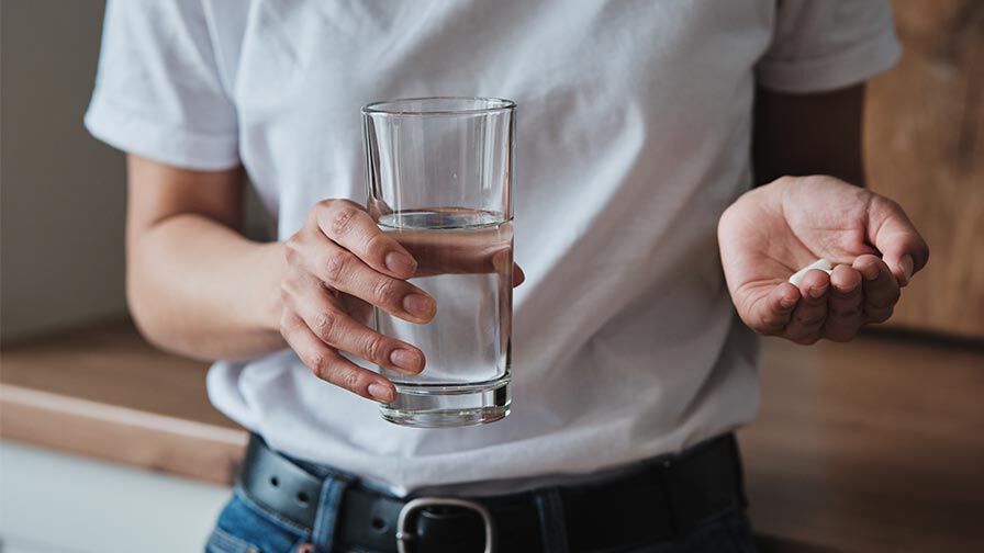 pessoa a segurar medicamentos como representação de anticoncecionais e antidepressivos e o impacto na líbido